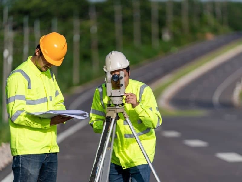Surveyor using equipment to verify road alignment, grades, and construction layout for a phased roadway project in Orlando FL